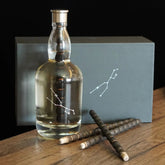 The complete Premium Oak Aged Bottle Kit, featuring the handcrafted glass decanter with constellation design, its gift box, and three charred oak aging sticks for whiskey.