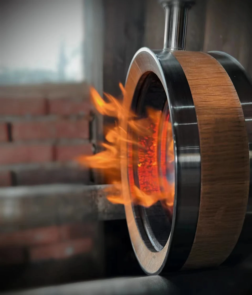 Flame toasting the inside of an oak whiskey decanter