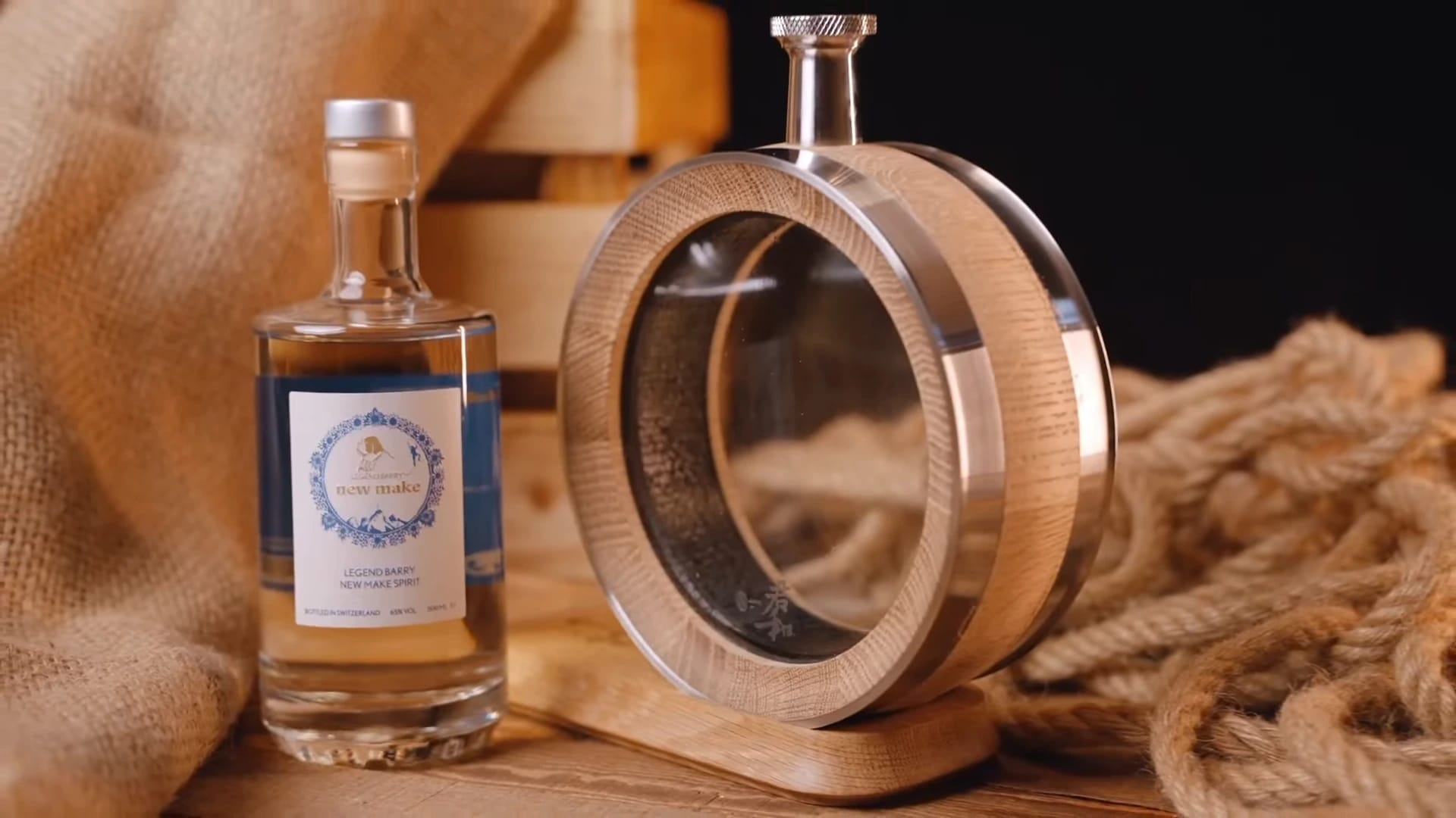A visible oak whiskey barrel beside a spirits bottle on a wooden table