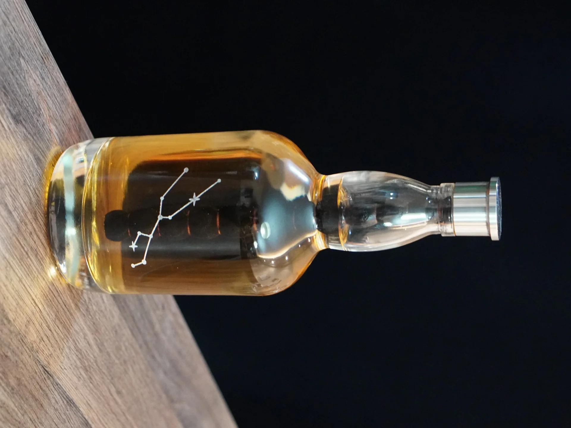 Aging Bottle filled with spirits on a wooden table