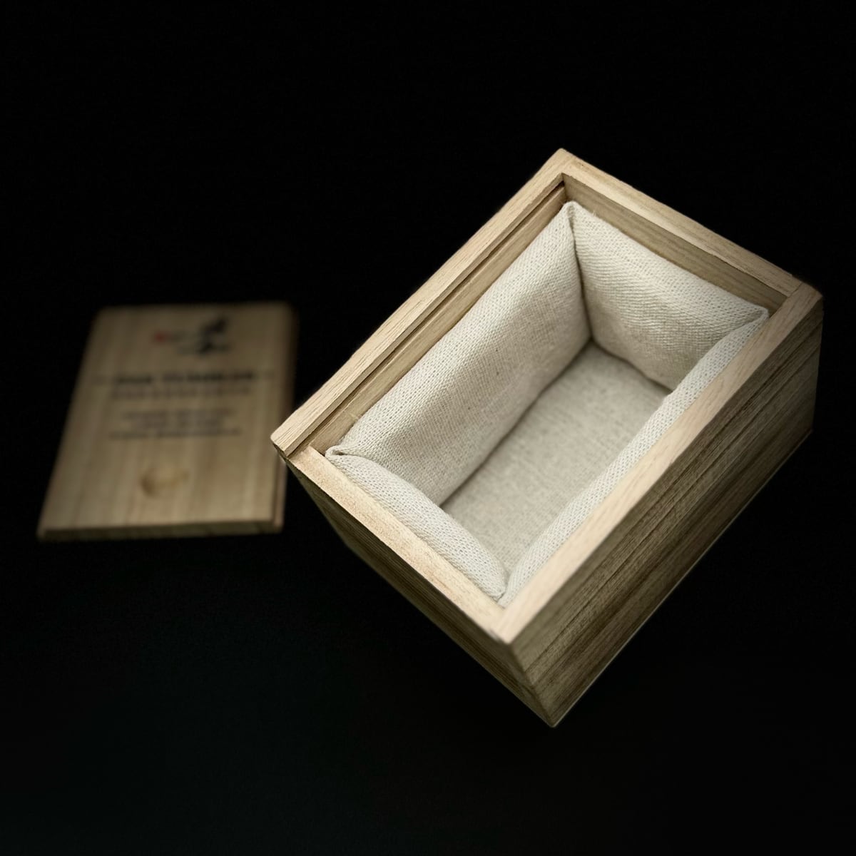 There is linen padding inside the pinewood box packaging of the oak whiskey tumbler.