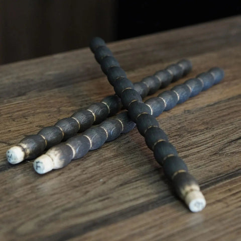 A close-up of three handcrafted, charred oak aging sticks from the whiskey aging kit, showing the detailed texture used to impart flavor into spirits.